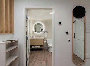Un baño moderno con tocador, inodoro y espejo.