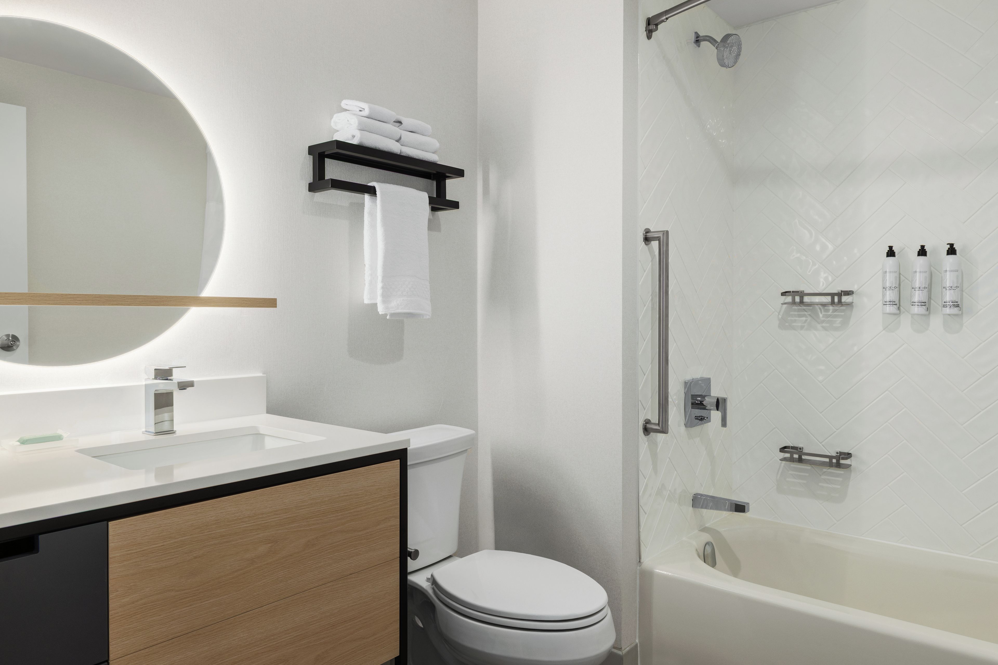 Un baño moderno con inodoro, lavamanos y ducha.
