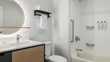 Un baño moderno con inodoro, lavamanos y ducha.