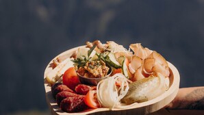 A wooden platter with various foods including sausages, cheese, and pickles. - Ski-in/ski-out Apartment Monte Central (Neukirchen am Grossvenediger)