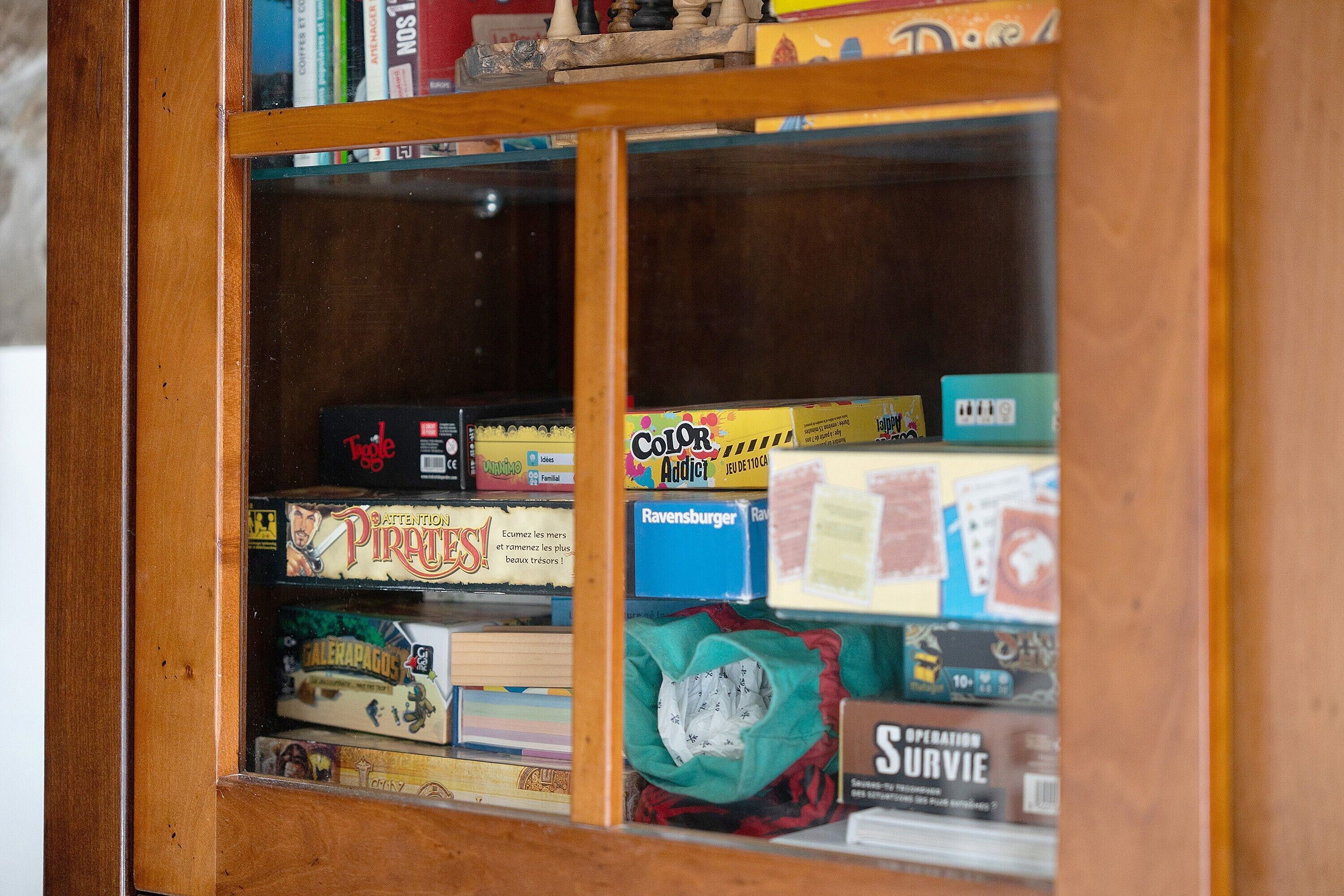 Una vitrina de madera con diversos juegos de mesa y rompecabezas.