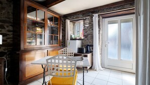 A kitchen with a wooden cabinet, a white table, and yellow chairs.