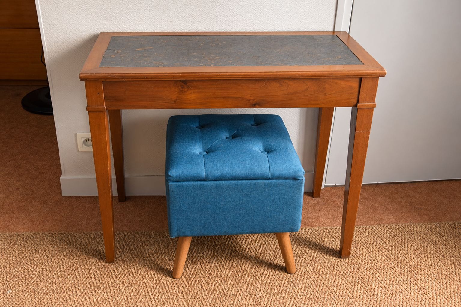 Una mesa de madera con un banco acolchado debajo.