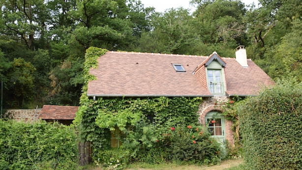 A rustic house with a brick facade, a tiled roof, and a small window. - Au Bon Séjour (Sainte-Suzanne-and-Chammes)