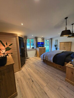 A bedroom with a bed, wooden wardrobe, and a television.