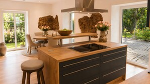 Una cucina moderna con isola centrale, mobili in legno e una parete decorativa in pietra.