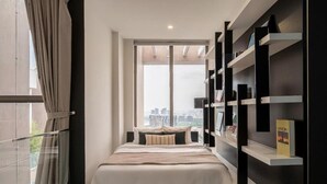 A modern bedroom with a bed, a large window, and a built-in bookshelf. - Stunning Penthouse in the City Centre (Ho Chi Minh City)