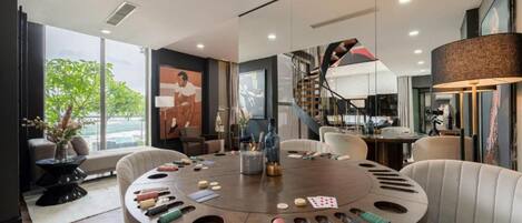 Un espace repas moderne avec une table ronde, des chaises et une vue sur l’extérieur.