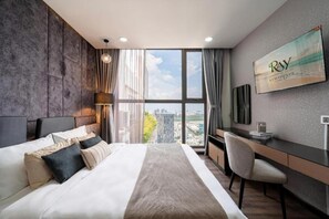 Una habitación de hotel moderna con una cama grande, un escritorio y vistas a la ciudad.