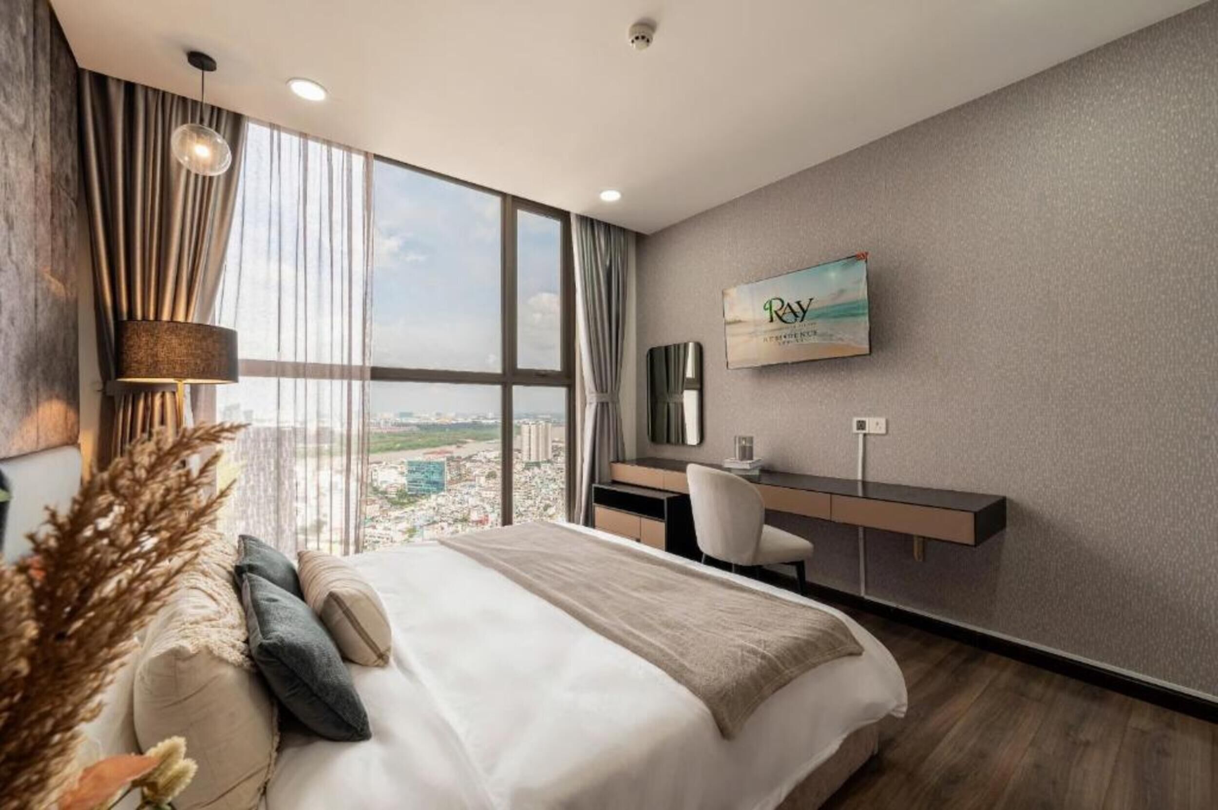Ett modernt hotellrum med en stor säng, ett skrivbord och utsikt över staden.