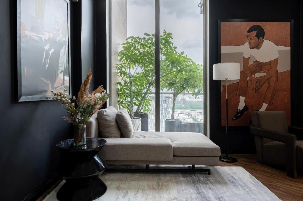 Una sala de estar moderna con un sofá, una lámpara de pie, un amplio ventanal con vistas y obras de arte en las paredes.