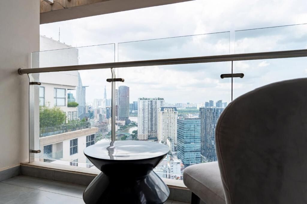 Une pièce moderne dotée d’une grande fenêtre, d’une table ronde noire et d’un fauteuil rembourré.