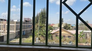 A window with a view of buildings and a clear sky. - Place to stay in Nairobi (Nairobi)