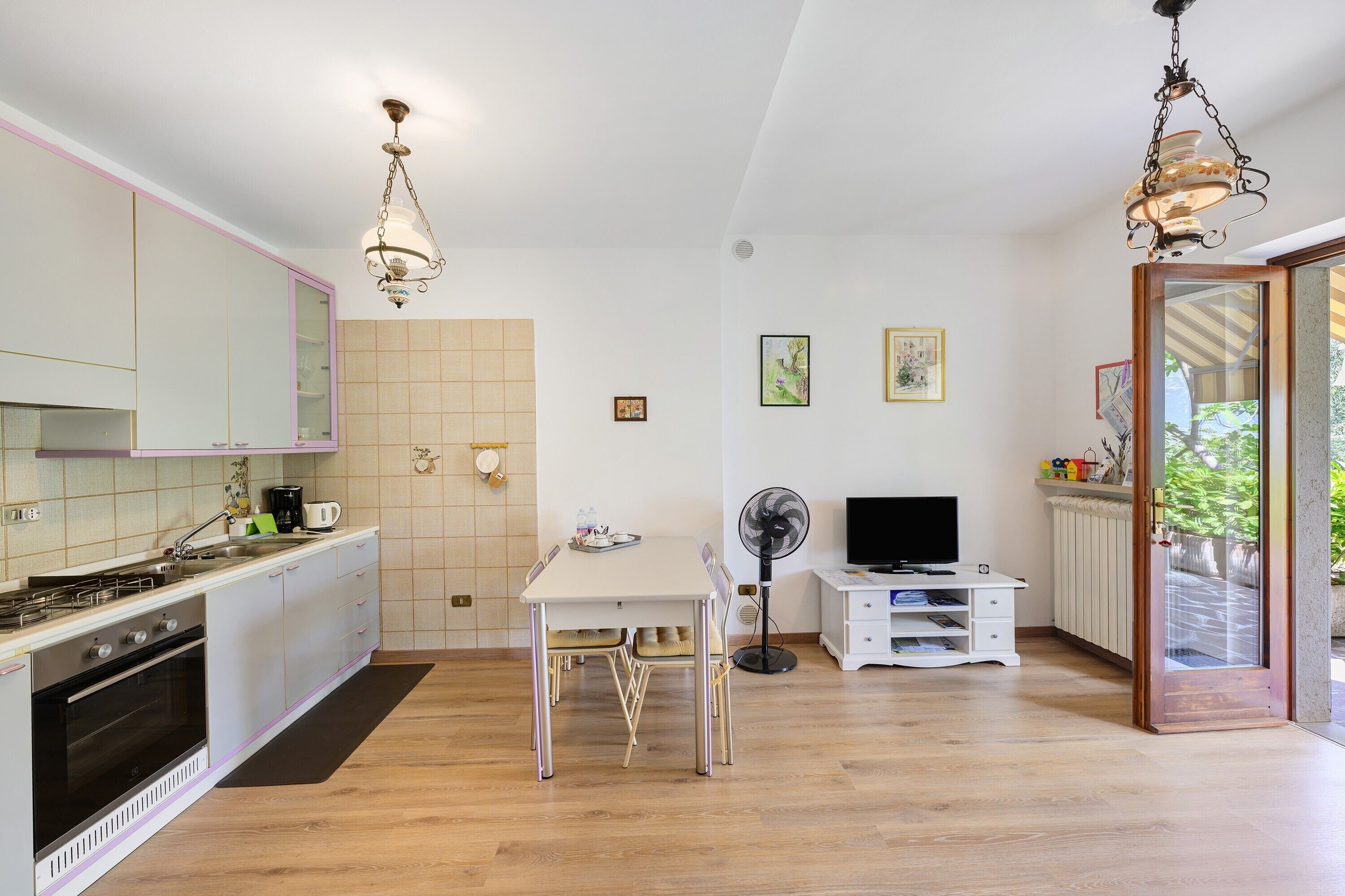 Una cucina moderna con zona pranzo, una ventola e un televisore.