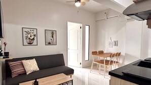 Ein modernes Wohnzimmer mit einer Couch, einem Couchtisch und einem Essbereich mit Stühlen.