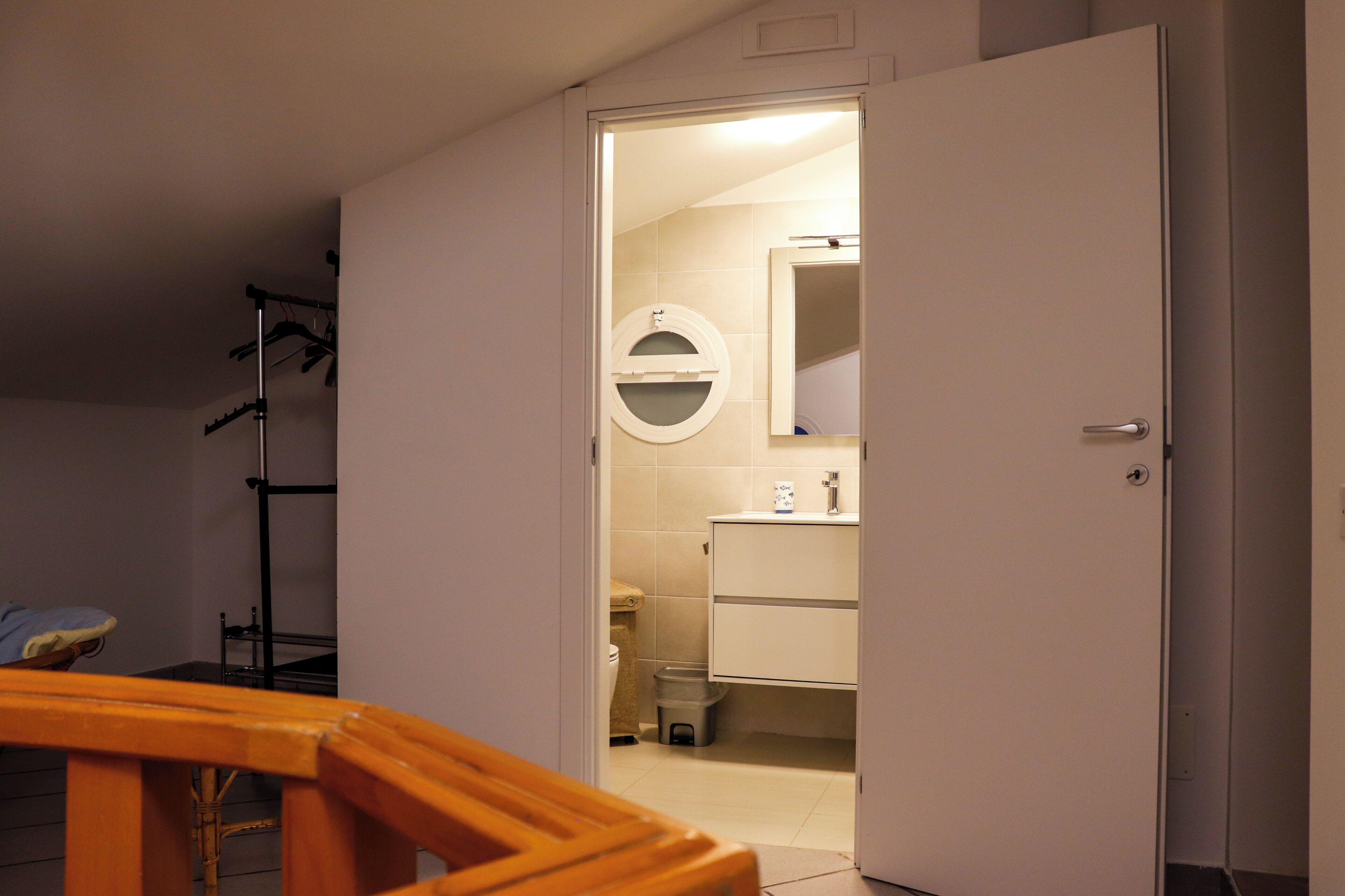 Een badkamer met toilet, wastafel en spiegel.