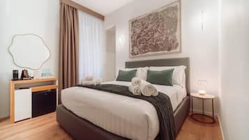 Ein Hotelzimmer mit Bett, Schreibtisch, Stuhl, kleinem Tisch und Wandlampe.