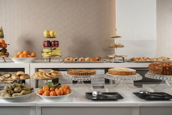 A buffet with various food items including fruits, pastries, and desserts. - ARCASuite Trevi (Rome)