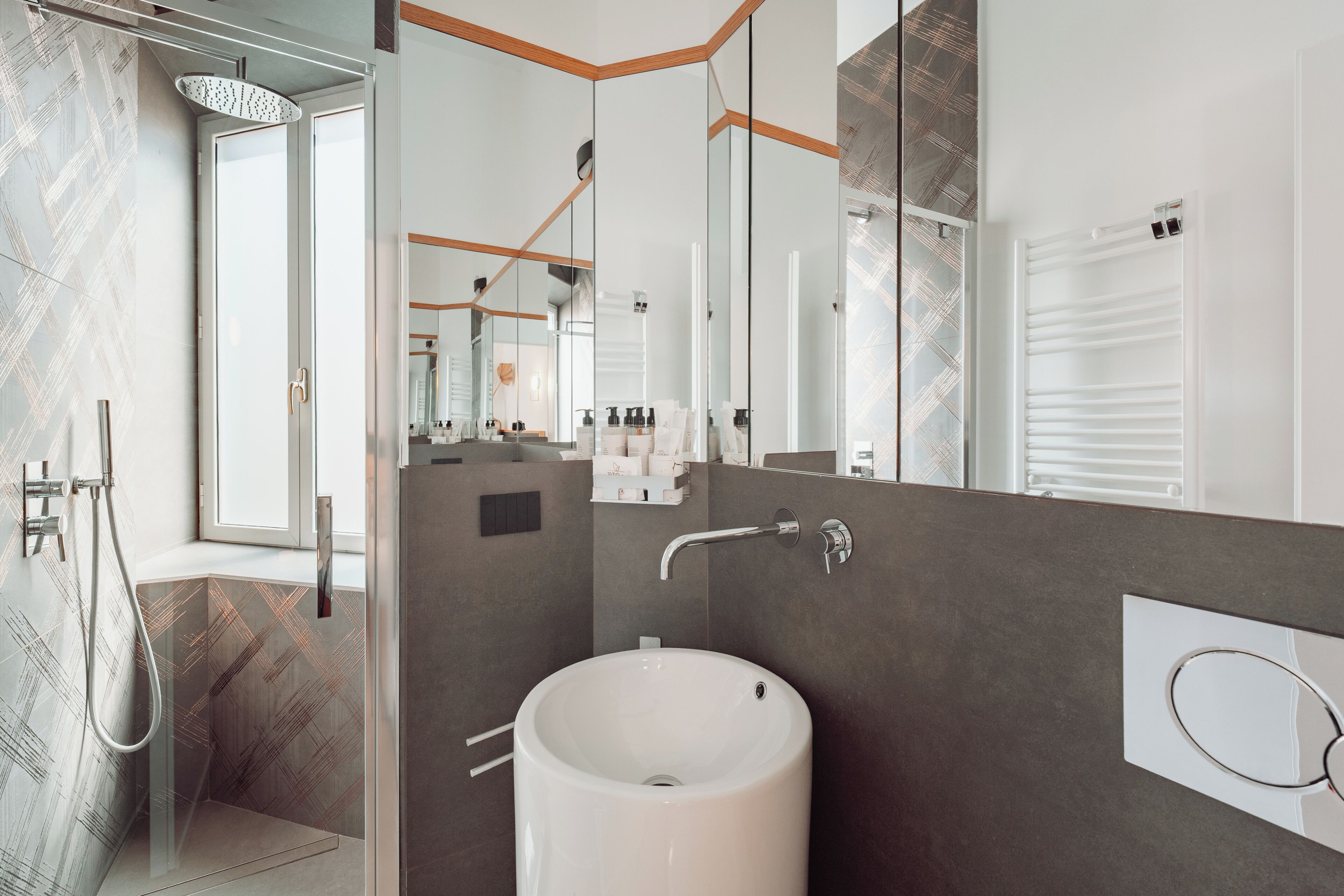 Een moderne badkamer met een grote spiegel, een wit wastafelmeubel en een douchecel.