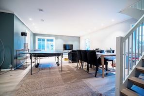 A modern kitchen with a dining area, a large window, and a staircase. - Newly built single-family home with its own spa area (Telemark)