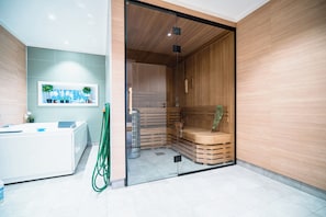 A modern bathroom with a glass shower enclosure, a white bathtub, and a wooden vanity. - Newly built single-family home with its own spa area (Telemark)