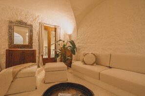 Ein gemütliches Wohnzimmer mit einer Couch, einem Hocker und einem Kamin.