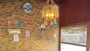 Una habitación acogedora con mobiliario de mimbre, un cartel de recepción y un candelabro decorativo.