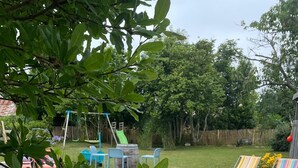 Un pati interior amb piscina, joguines inflables per a la piscina i un terra de fusta.