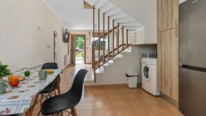 A kitchen with a dining area, a washing machine, and a staircase.