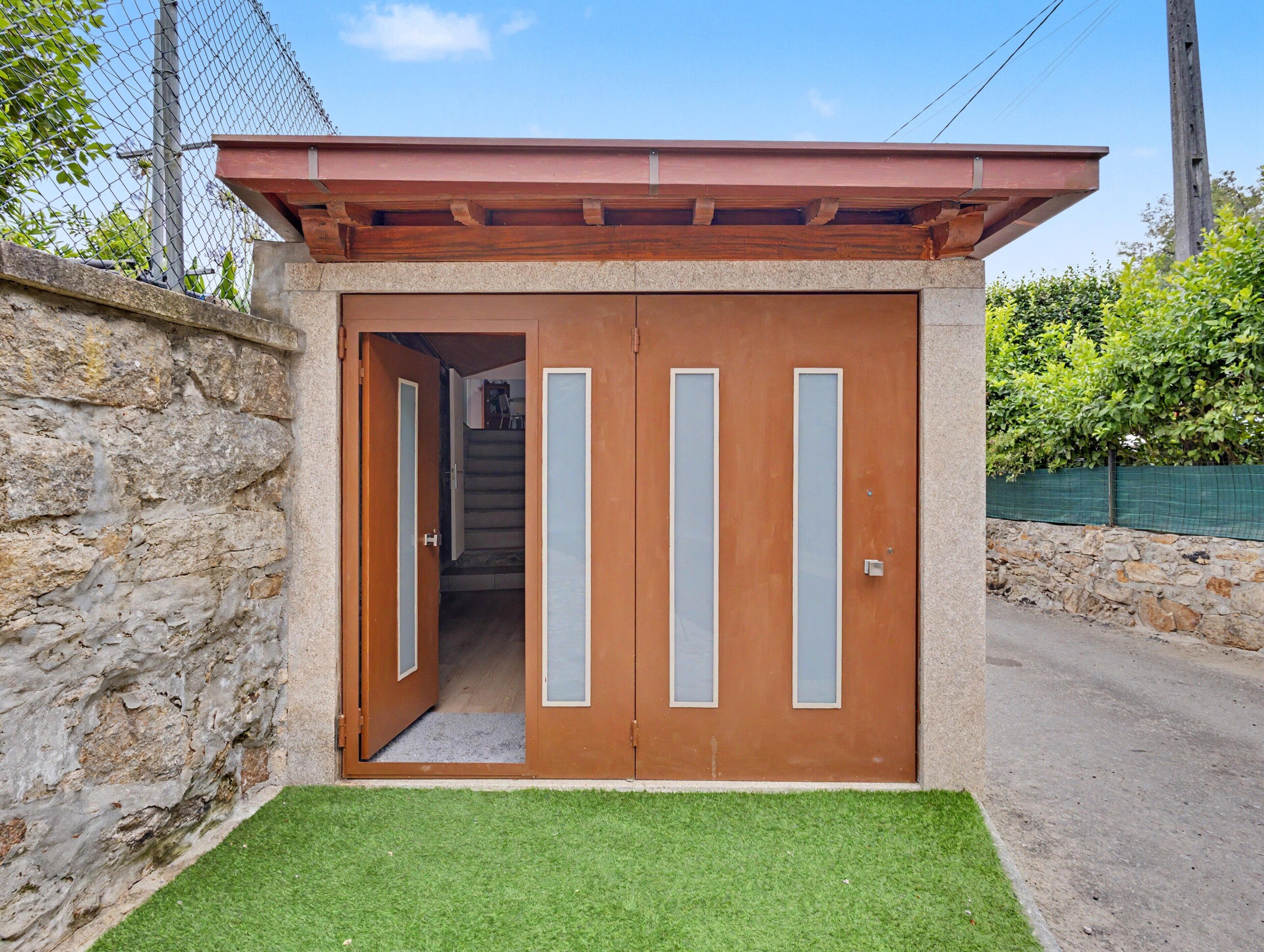 Una construcció petita i tancada amb una porta de fusta i un petit porxo.