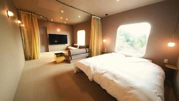 Habitación de hotel con una cama grande, televisión de pantalla plana, escritorio y ventana con cortinas.