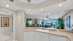 A modern kitchen with a large island, built-in appliances, and a view to the outdoors. - Barbados at the Dunes (Naples)