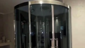Een kamer met glazen wanden, een rond ontwerp, een witte basis en een zichtbaar bedieningspaneel.
