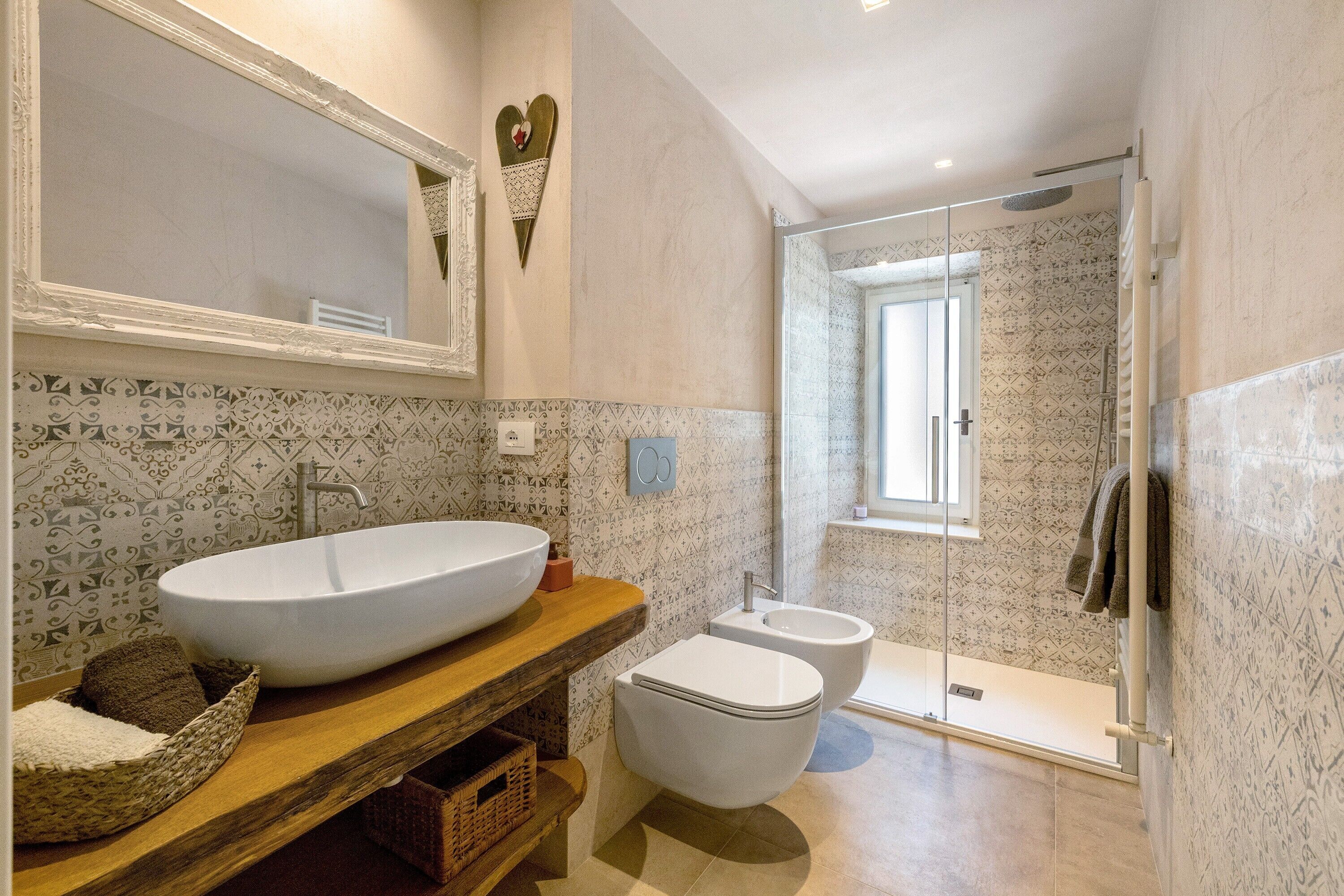 Un bagno con un lavabo a bacinella, un WC e un box doccia in vetro.