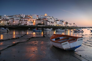 A coastal town with boats docked along the shore, buildings with white and pink facades, and a clear sky. - Casa Eldorado Luxury Villa with Private Pool in Ferragudo (Ferragudo)
