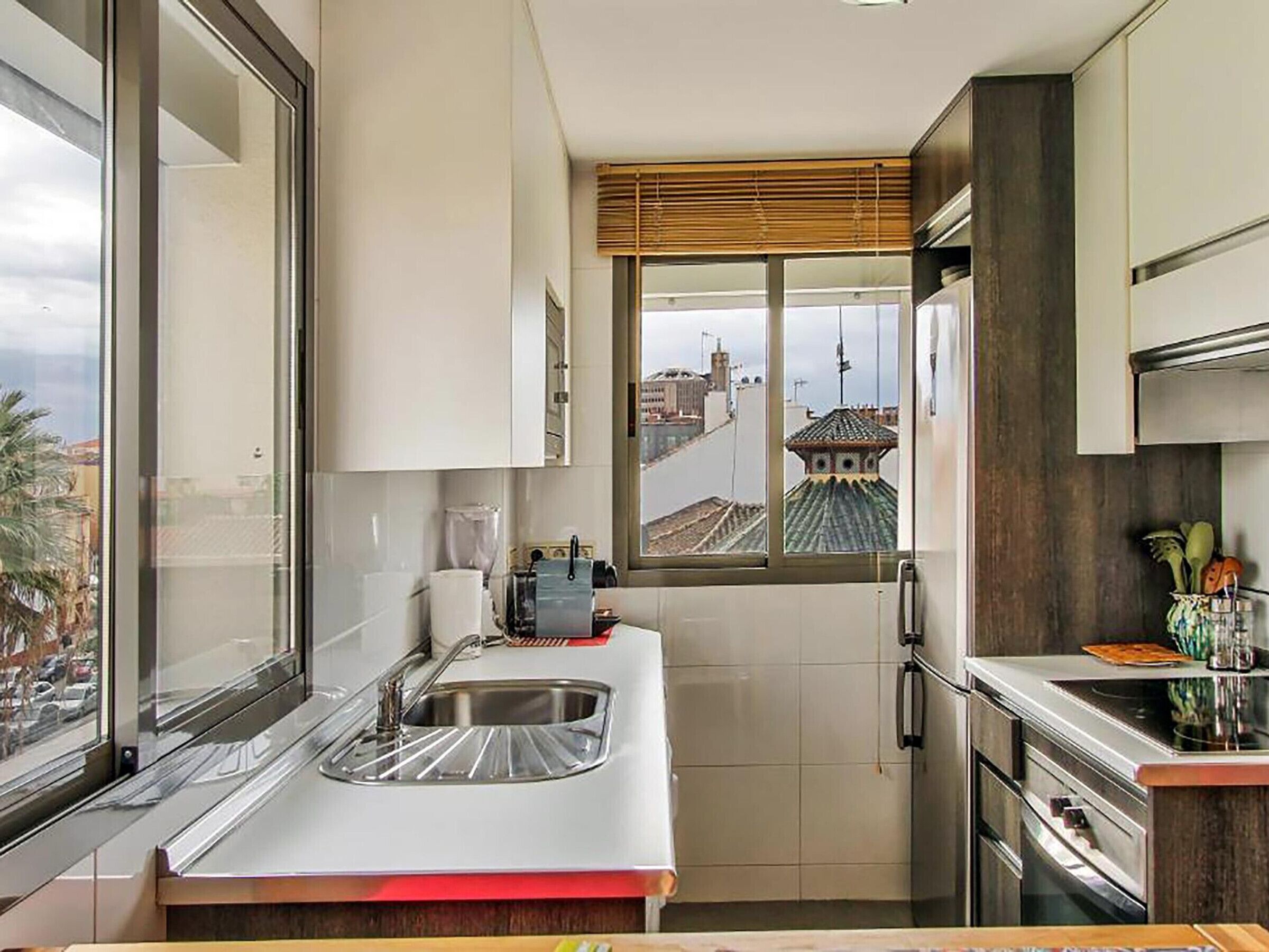 Una cucina compatta con finestra, lavello e piano cottura.
