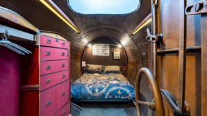 A compact, cozy room with a bunk bed, a red dresser with multiple drawers, and a small window. - Unique lodging, steampunk vibe - 2 guests (Raon-aux-Bois)