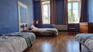 A bedroom with two beds, a dresser, a chair, and a window with curtains. - Welcoming gîte near Verdun - 7 guests (Brainville)
