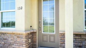 A beige door with a glass panel, a keypad lock, and a number '132' on the wall. - Bright 4BR w PS4 Mickey Rooms at Holly Village 132 (Davenport)