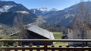 A mountain landscape with a wooden cabin and a white building in the foreground. - Cozy chalet, pets welcome, mountain view - 11 guests (Beaufort)
