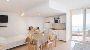 A modern apartment with a dining area, kitchenette, and a balcony with a view. - Studio cab, AC, sea view, parking - 4 guests (Sète)