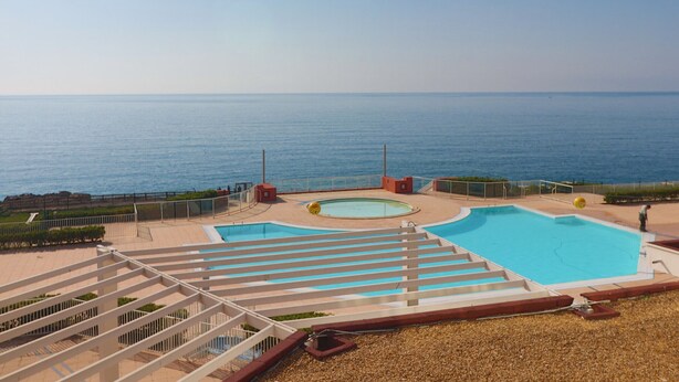 A pool area with a view of the sea, a pergola, and a small building. - Studio cab, AC, sea view, parking - 4 guests (Sète)