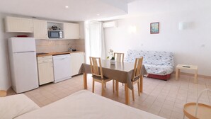 A compact hotel room with a kitchenette, a dining area, and a bed. - Studio cab, AC, sea view, parking - 4 guests (Sète)