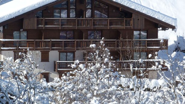 A multi-story wooden building with balconies, surrounded by snow-covered trees. - Cozy apartment near shuttles - 4 guests (Arêches-Beaufort)