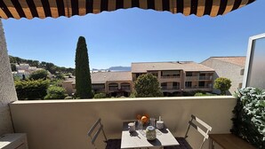Una terraza con una mesa, sillas y vistas a edificios.