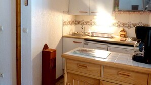 Eine Küche mit weißen Schränken, einer Kaffeemaschine und einem Spülbecken.