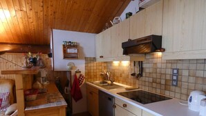 Eine Küche mit Holzausstattung, einem Herd, einer Spüle und einer Kaffeemaschine.