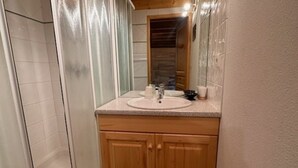 Een badkamer met een houten wastafelmeubel, een wastafel en een spiegel.