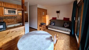 A compact living space with a kitchenette, a sofa, and a dining area. - Apartment close to slopes - 4 guests (Arêches-Beaufort)