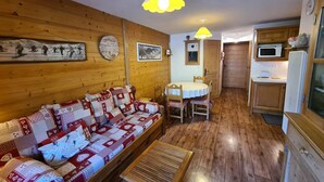 Ein gemütliches Blockhaus-Interieur mit einer Holzsofa, einem Esstisch und einer Küchenzeile.